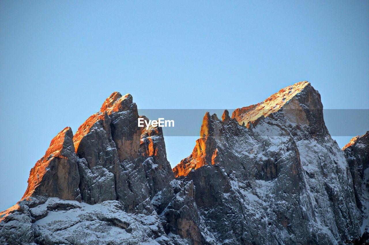 Low angle view of snow covered mountain against clear sky