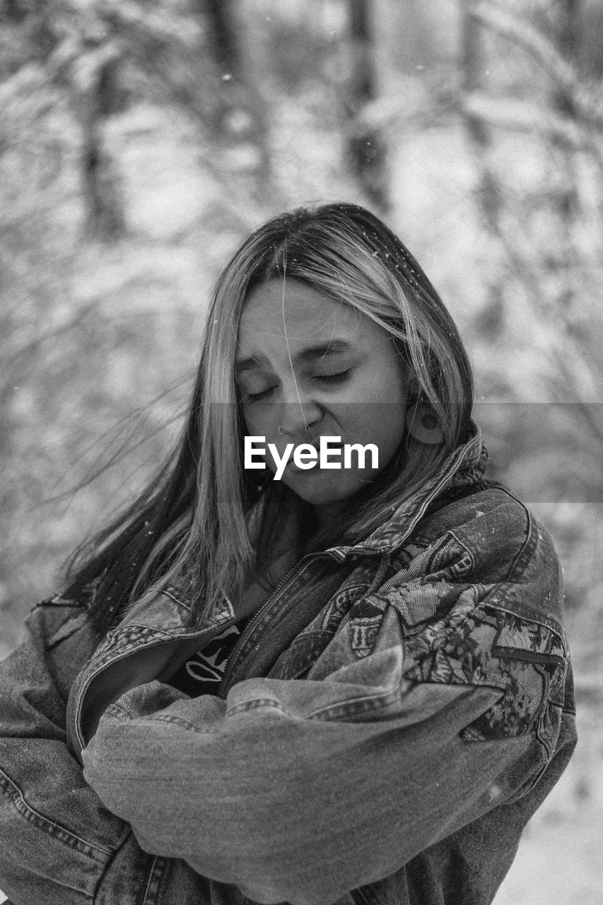 Girl making face while standing outdoors during winter