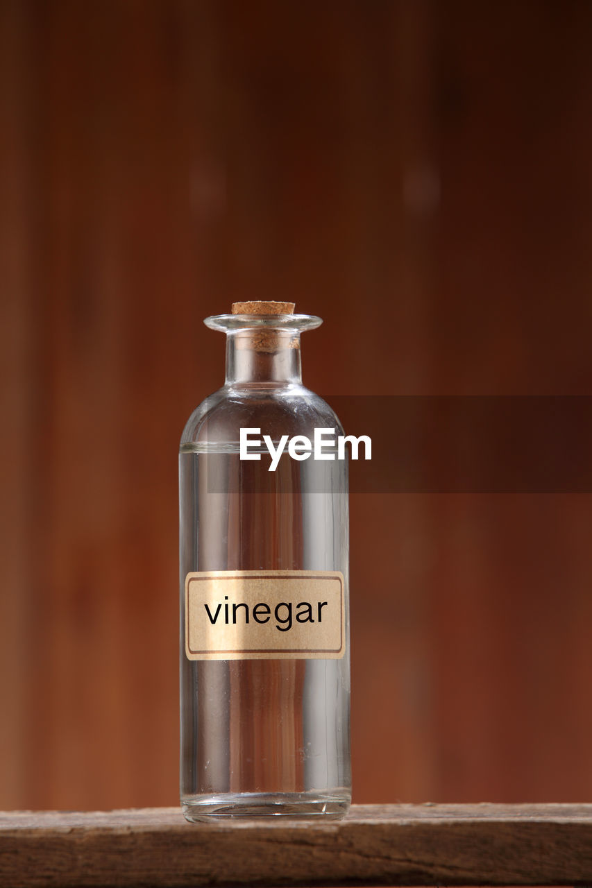 White vinegar on wooden background