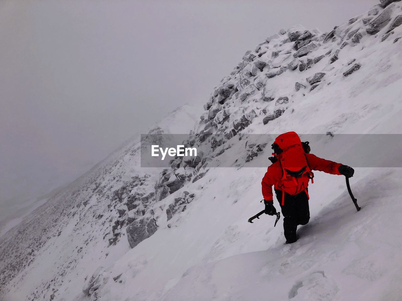 High angle view of man climbing snowcapped mountain