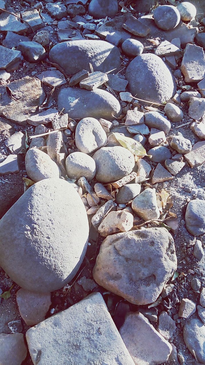 HIGH ANGLE VIEW OF STONES ON PEBBLES