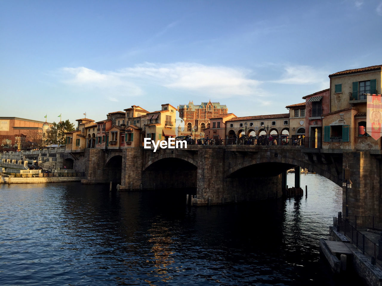 Bridge over river against buildings in city