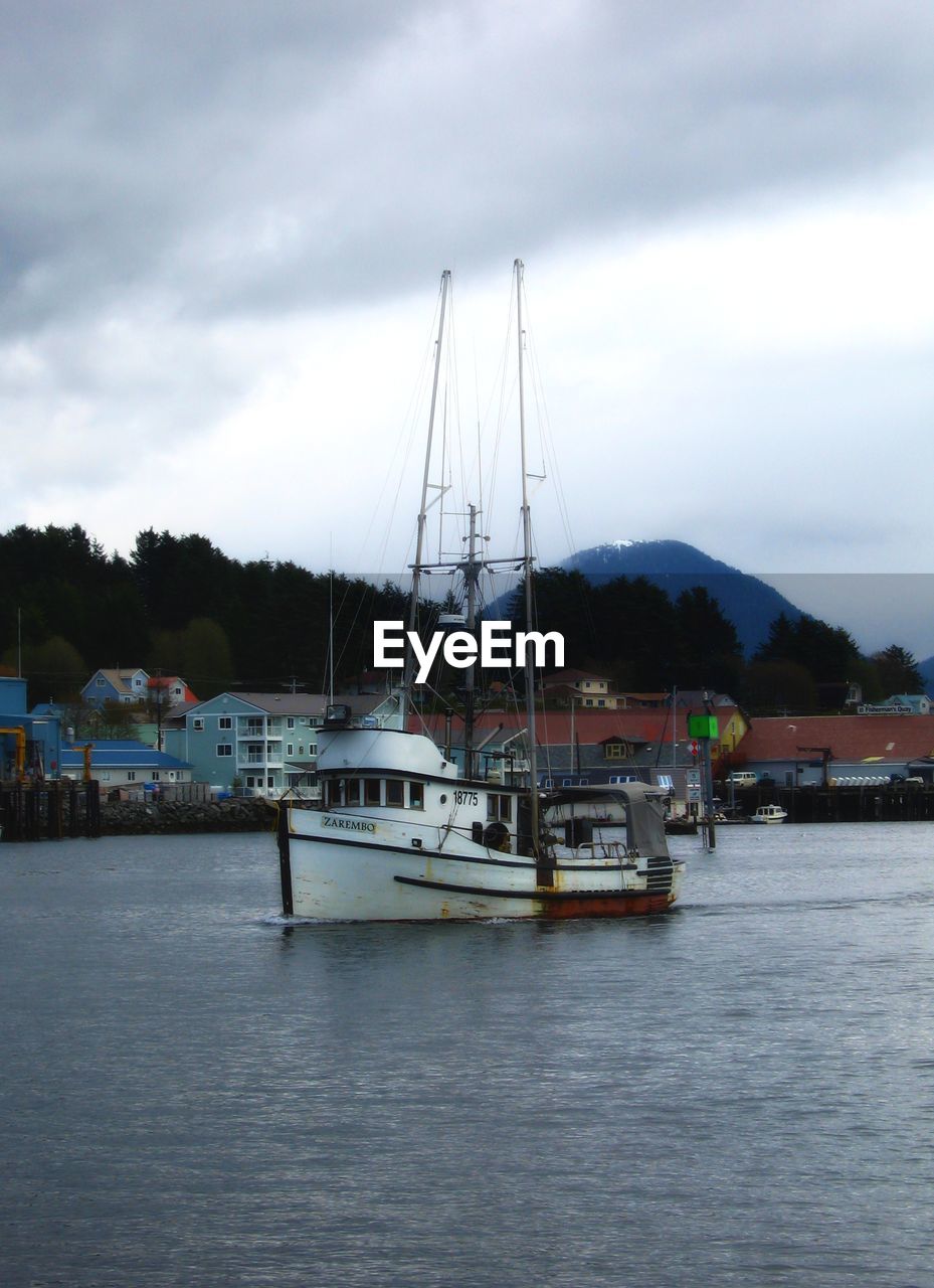 BOATS IN SEA WITH MOUNTAIN RANGE IN BACKGROUND