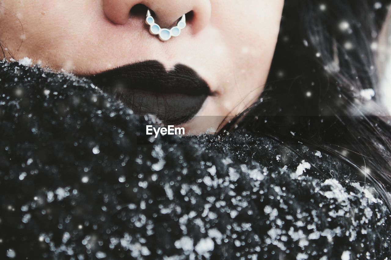 Cropped image of woman with black lipstick during snowfall