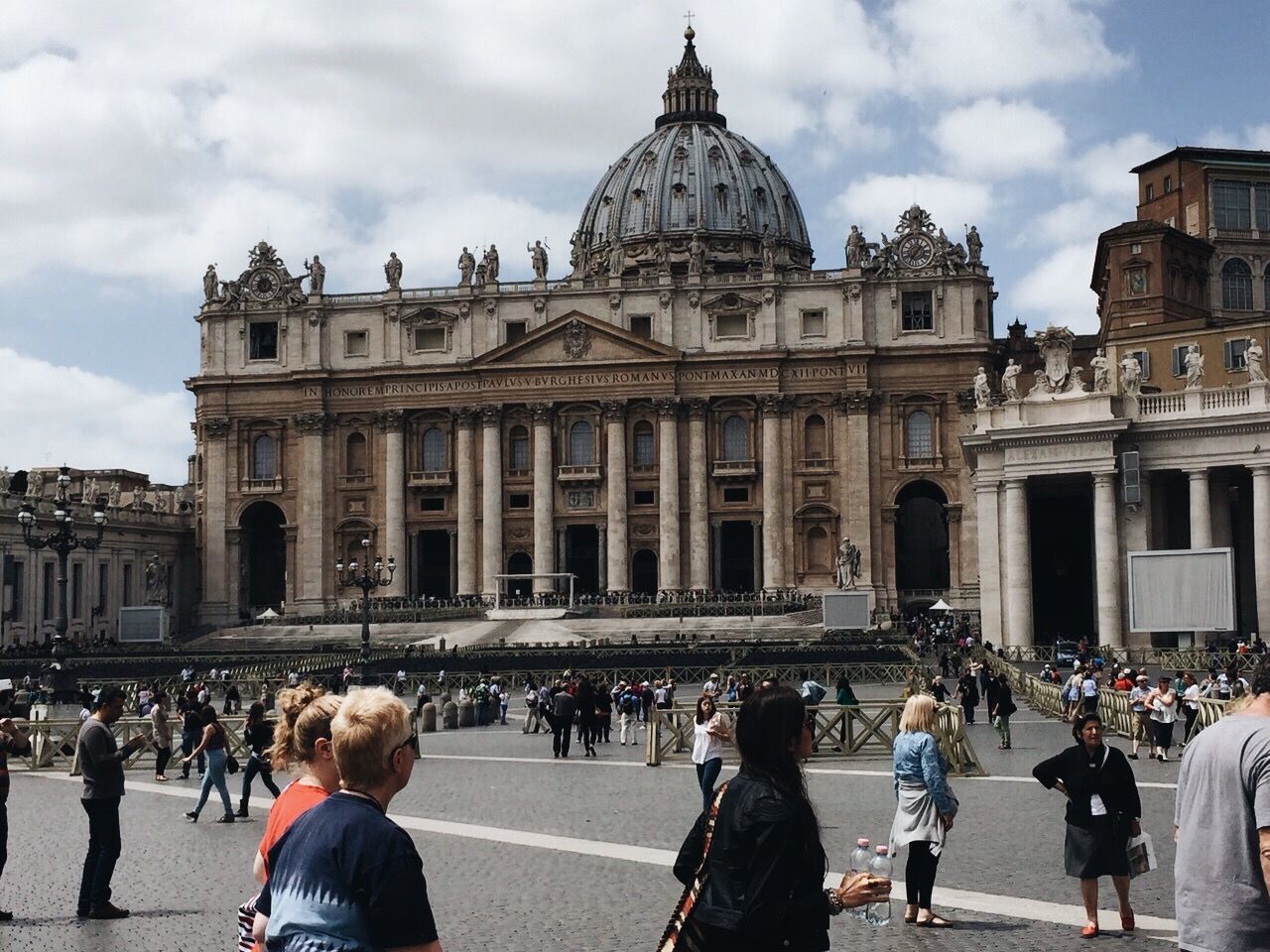 People at town square by sistine chapel against sky