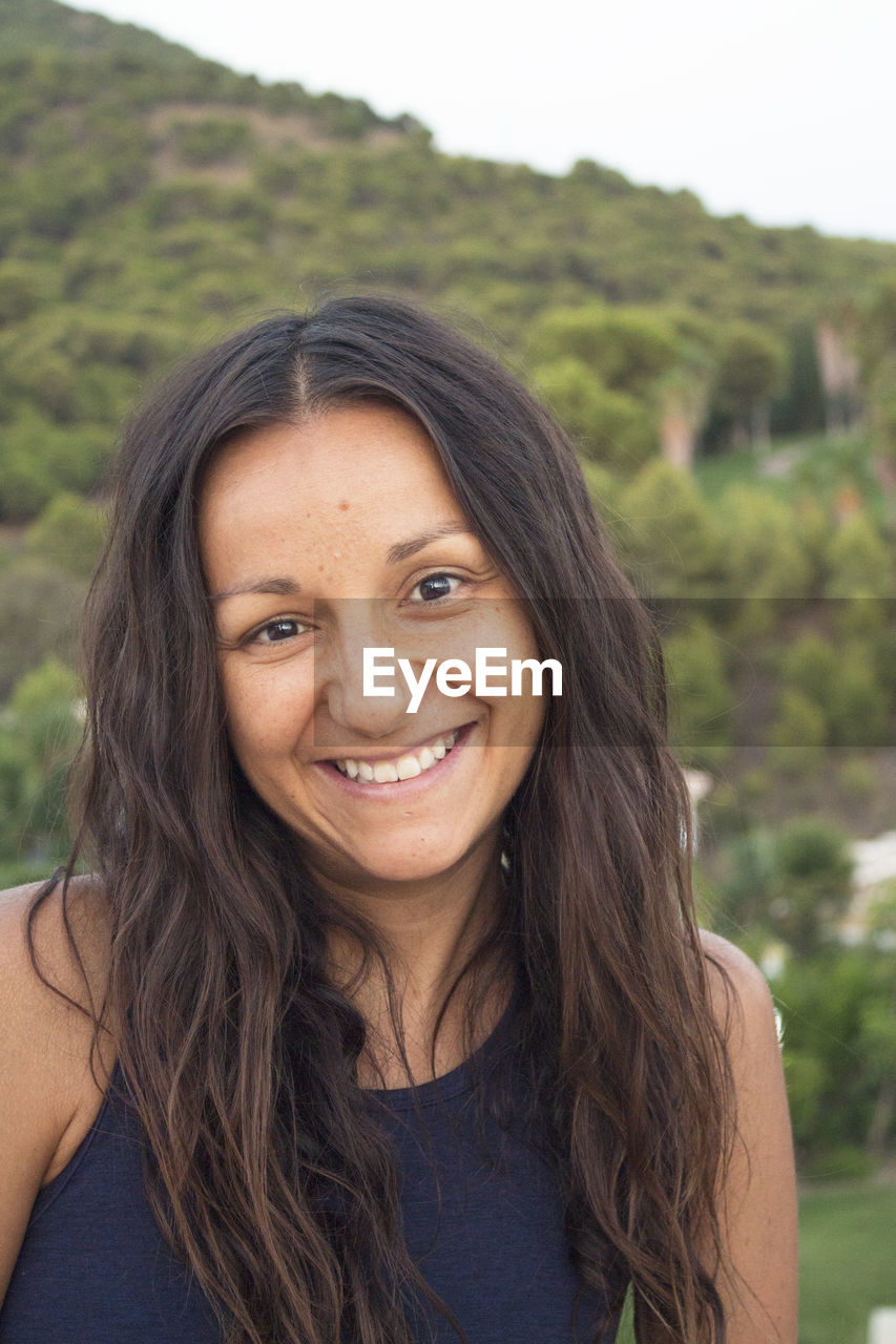 Portrait of youthful woman on mountain background. smiling.