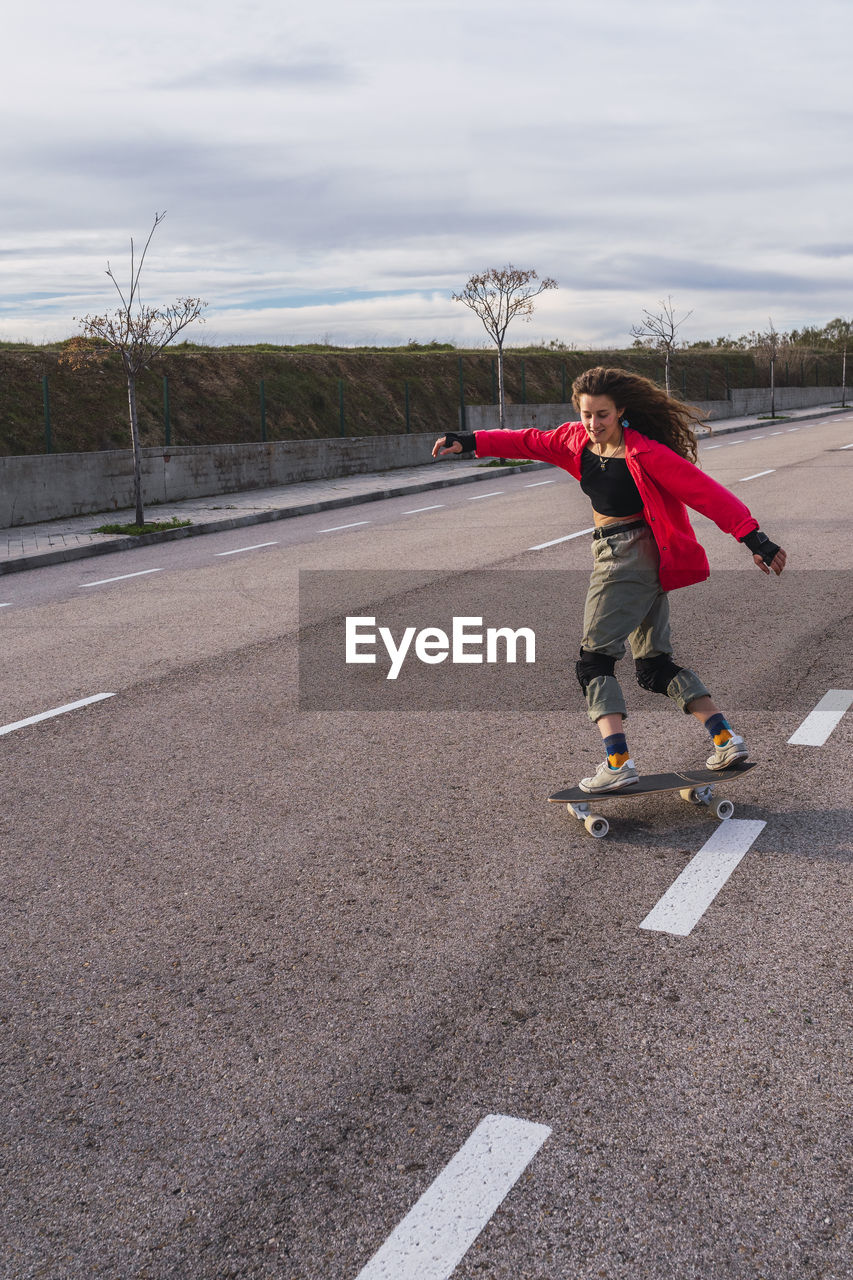 Woman skating with skateboard on road