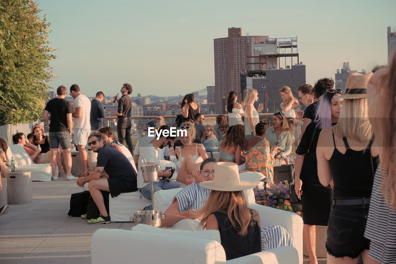 GROUP OF PEOPLE IN FRONT OF CITY BUILDINGS