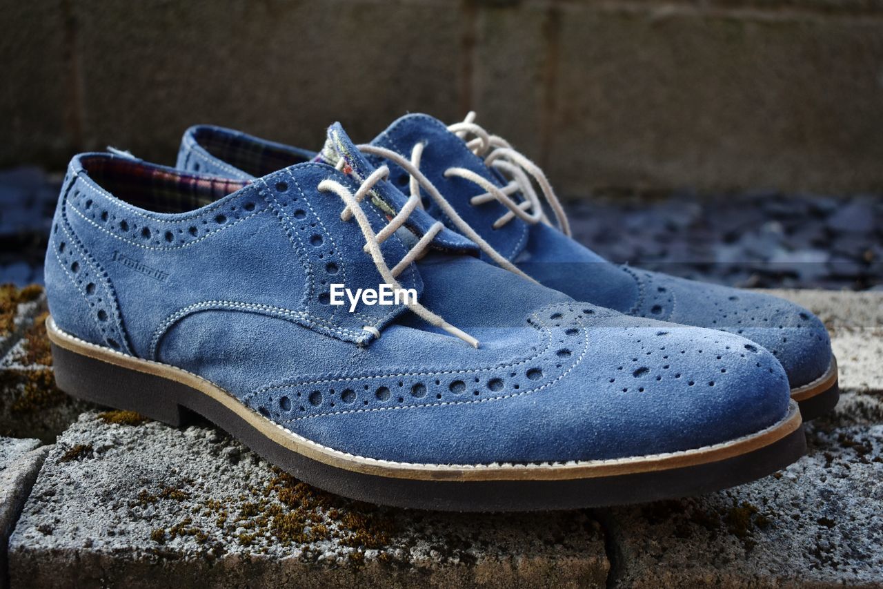 CLOSE-UP OF SHOES ON STONE