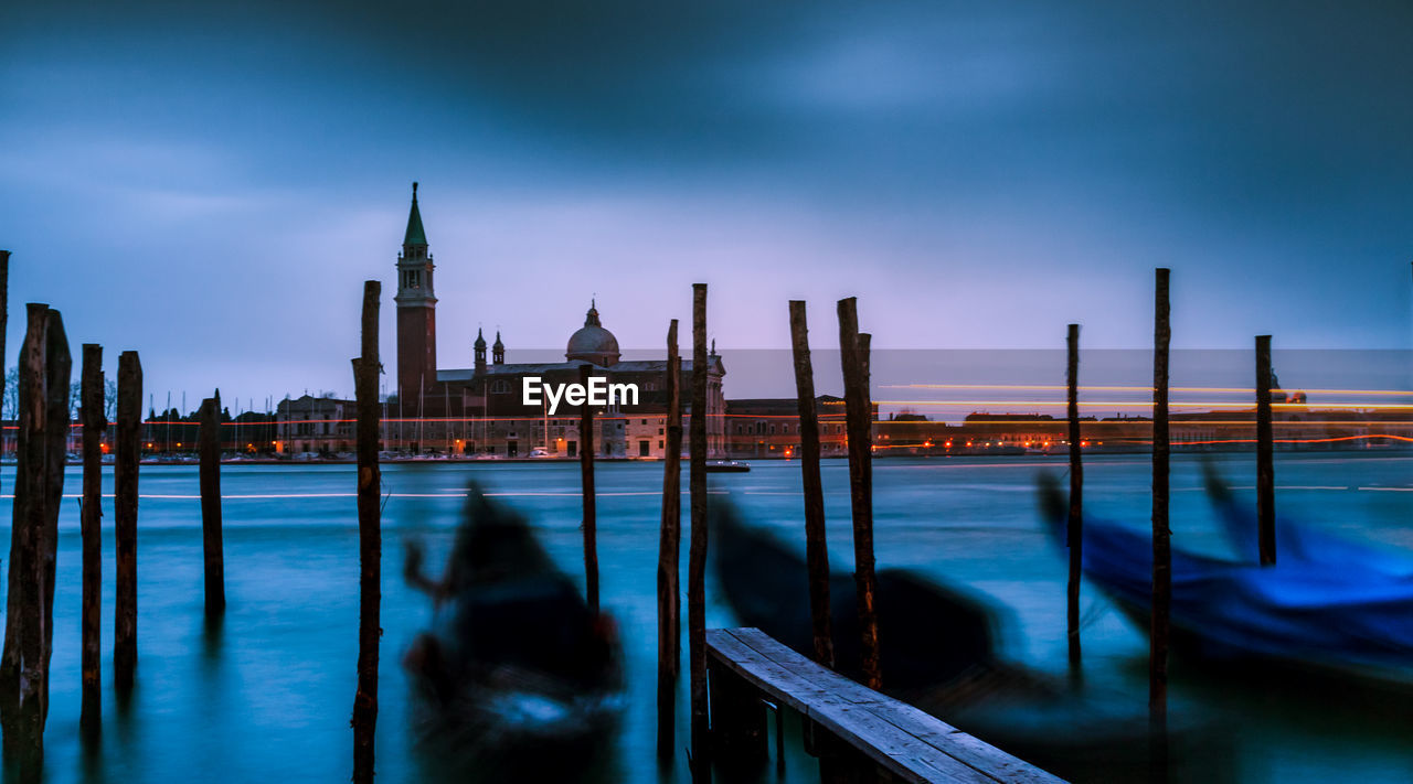 Wooden posts in grand canal at dusk