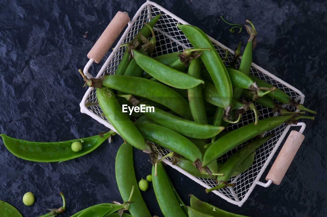 Directly above shot of green peas in basket on table