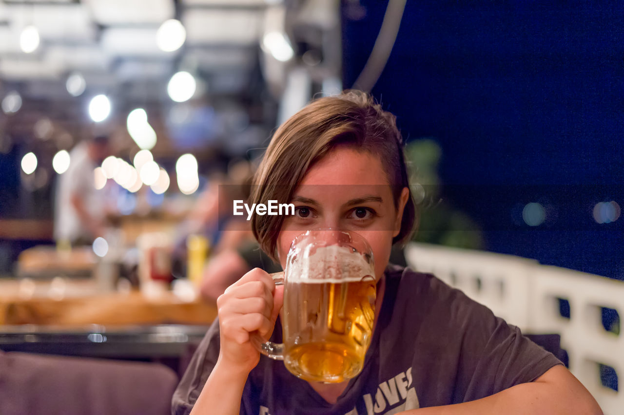 Close-up of young woman drinking beer