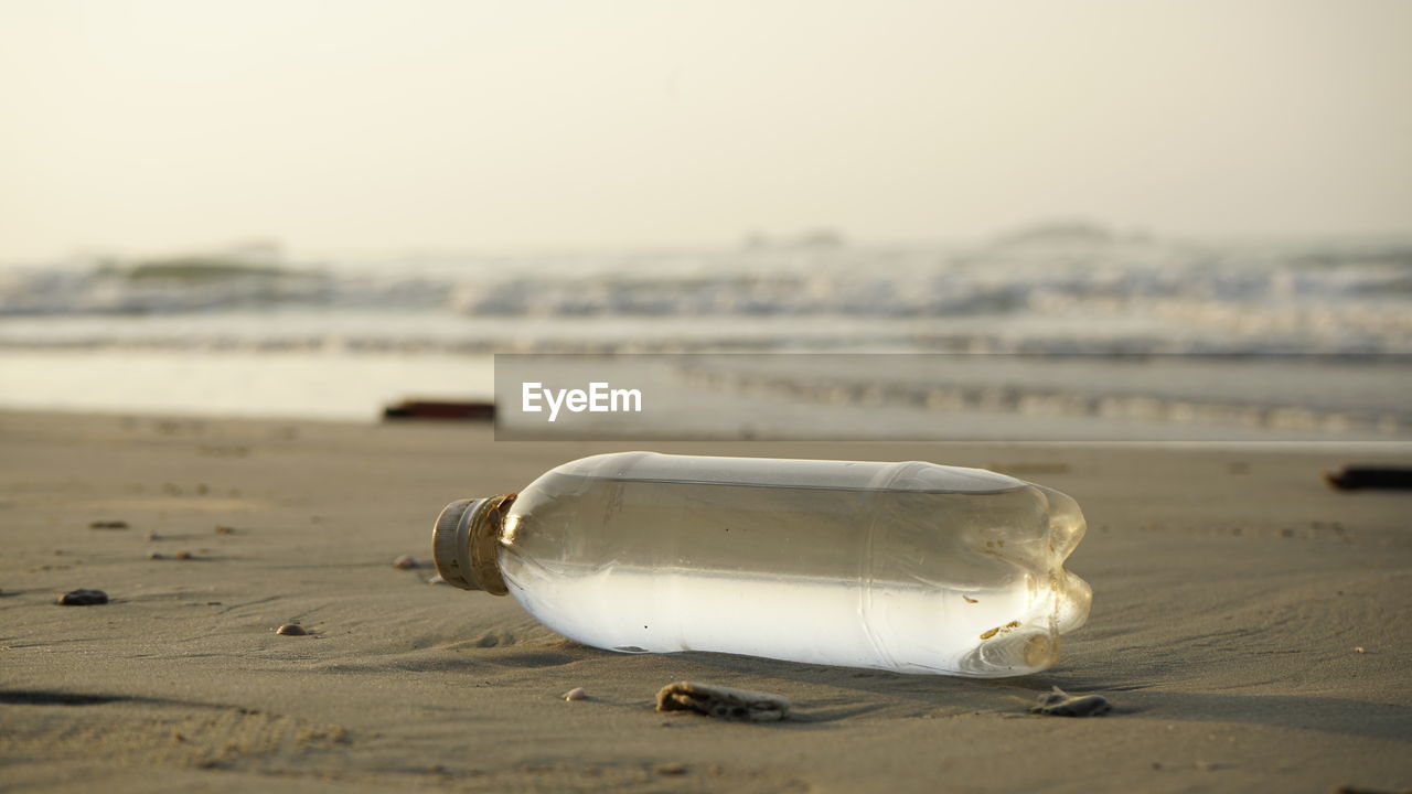 CLOSE-UP OF GARBAGE ON BEACH