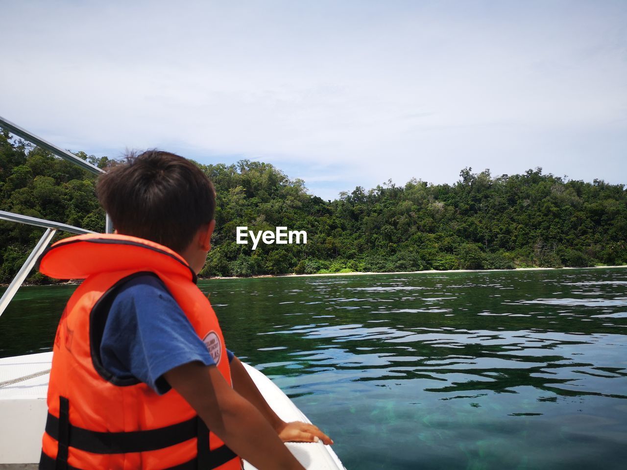 REAR VIEW OF MAN ON BOAT AGAINST SKY