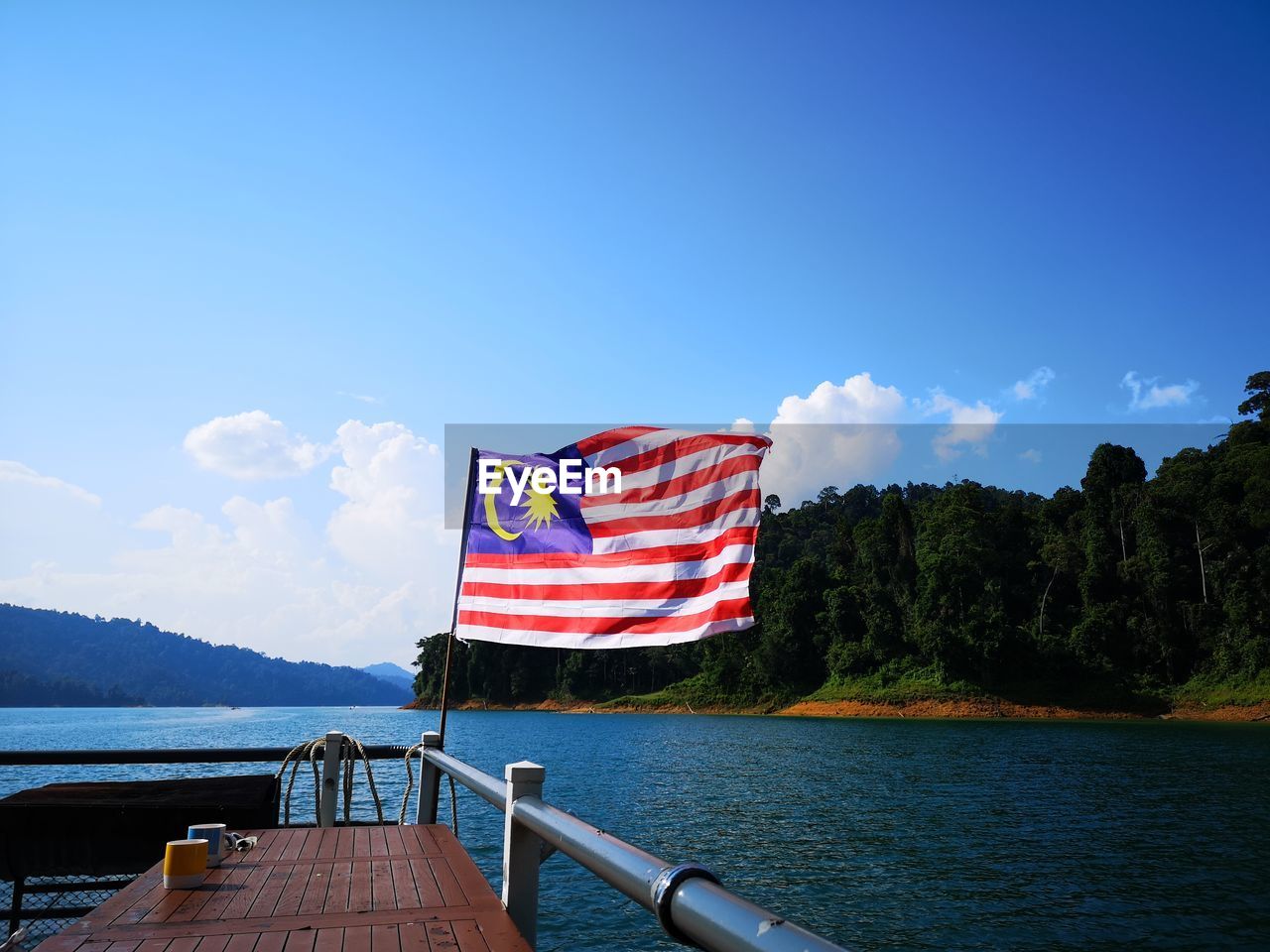 FLAG ON BOAT AGAINST BLUE SKY