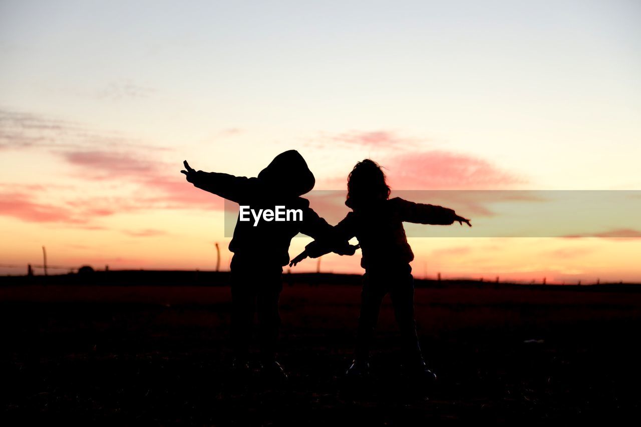 SILHOUETTE OF CHILD ON FIELD DURING SUNSET