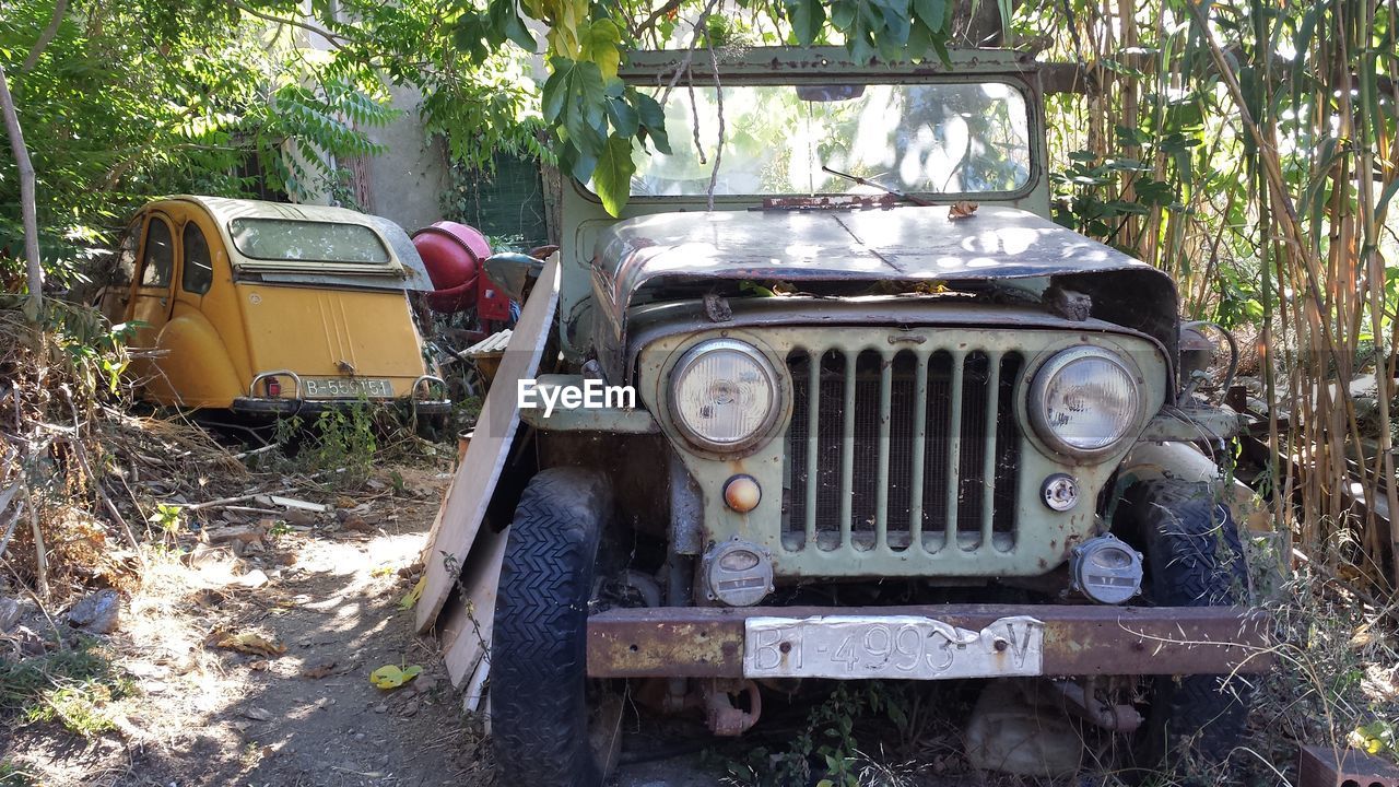 ABANDONED VINTAGE CAR ON RUSTY VEHICLE