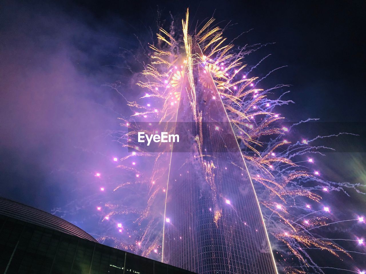 Low angle view of fireworks against sky at night