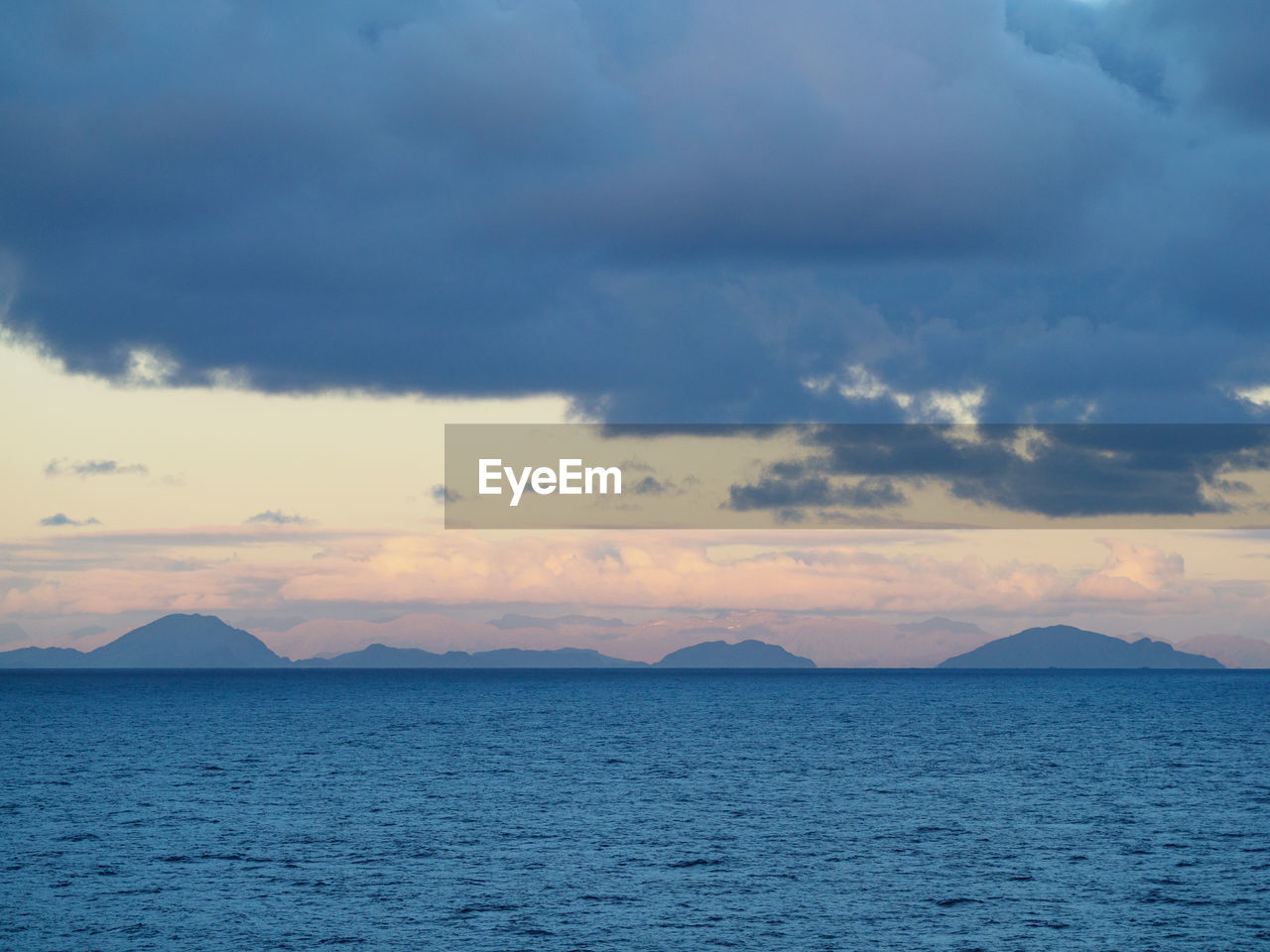 SCENIC VIEW OF SEA BY MOUNTAINS AGAINST SKY