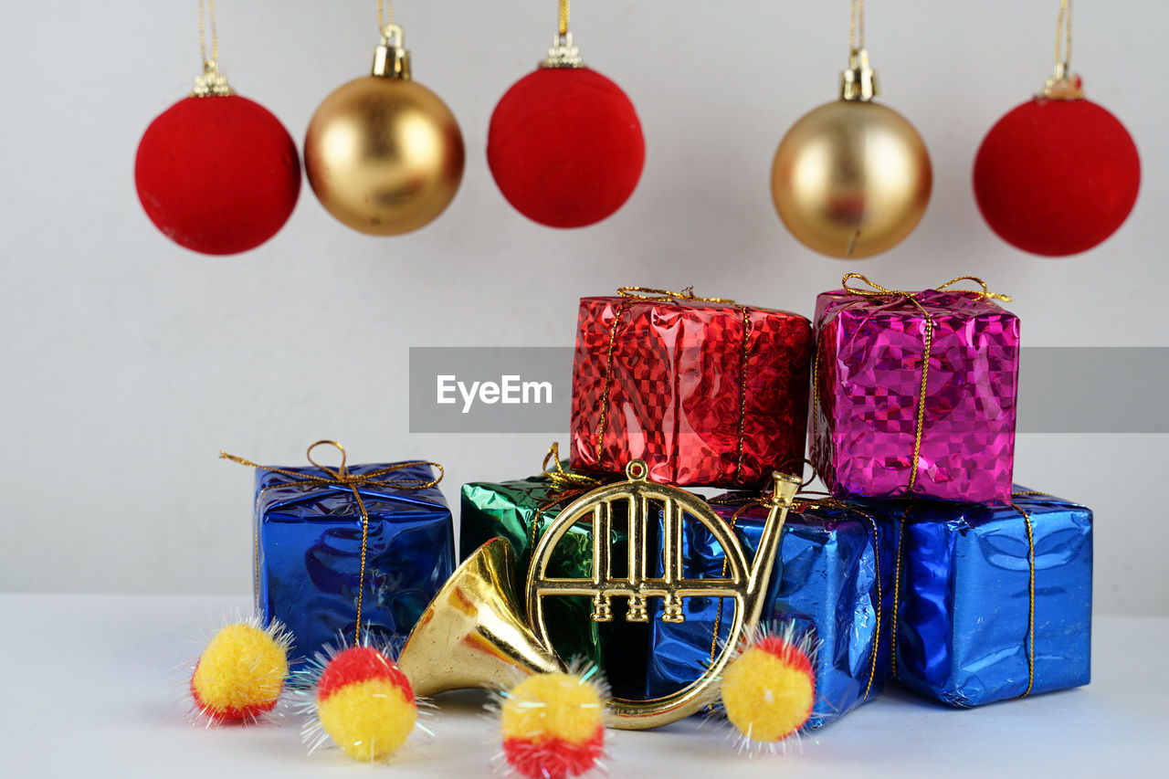 CLOSE-UP OF MULTI COLORED CHRISTMAS DECORATIONS ON TABLE