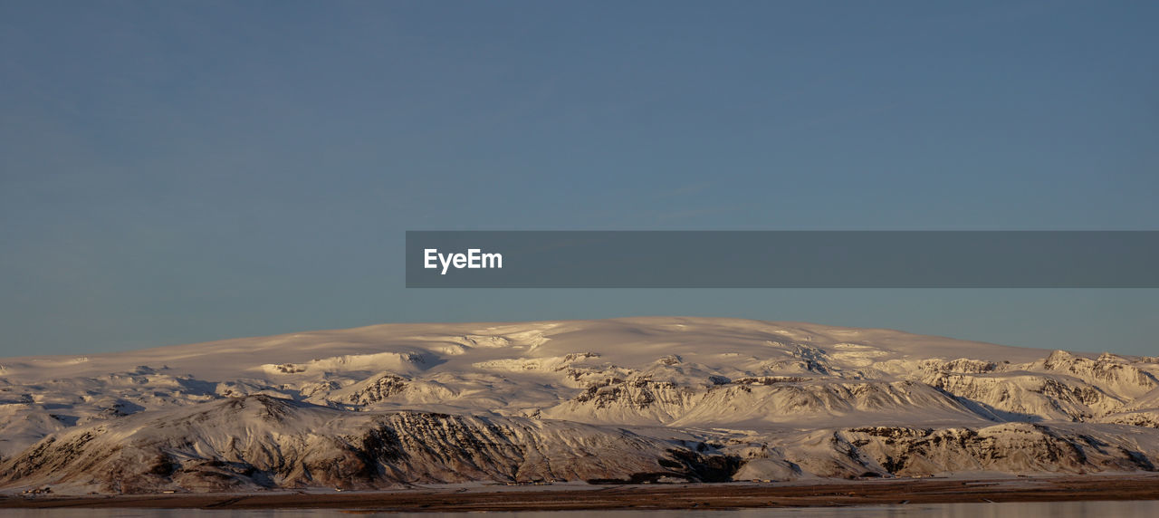 Scenic view of snowcapped mountains against clear sky