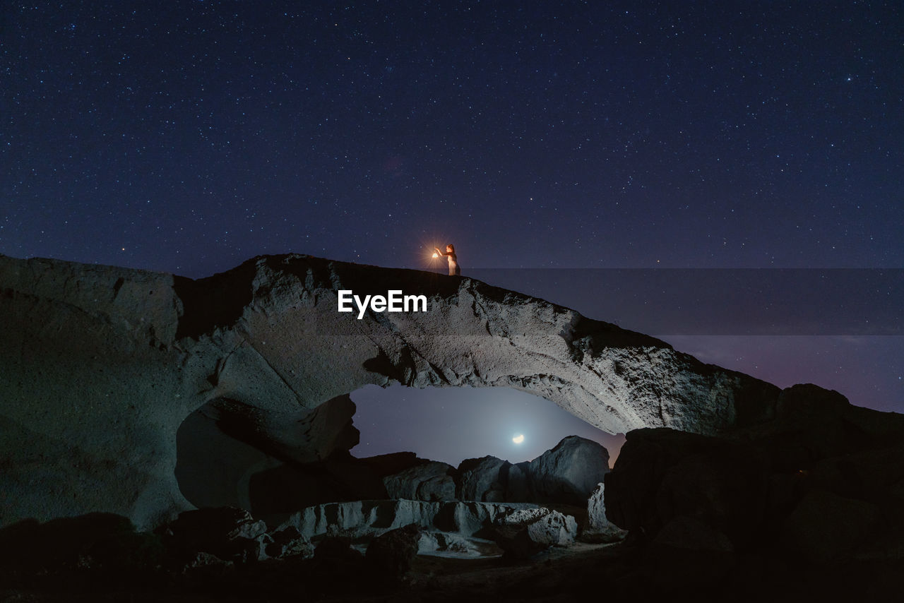 View of illuminated mountains against sky at night