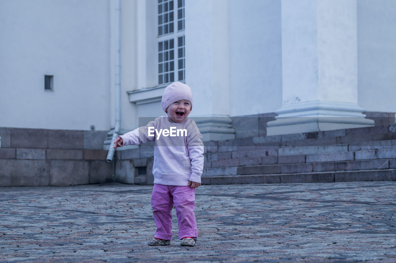 Full length of cheerful baby boy standing on street