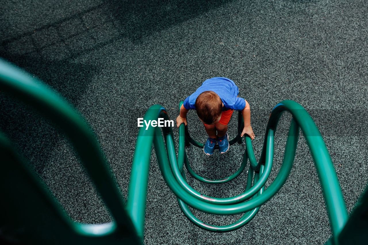 High angle view of boy playing on outdoor play equipment