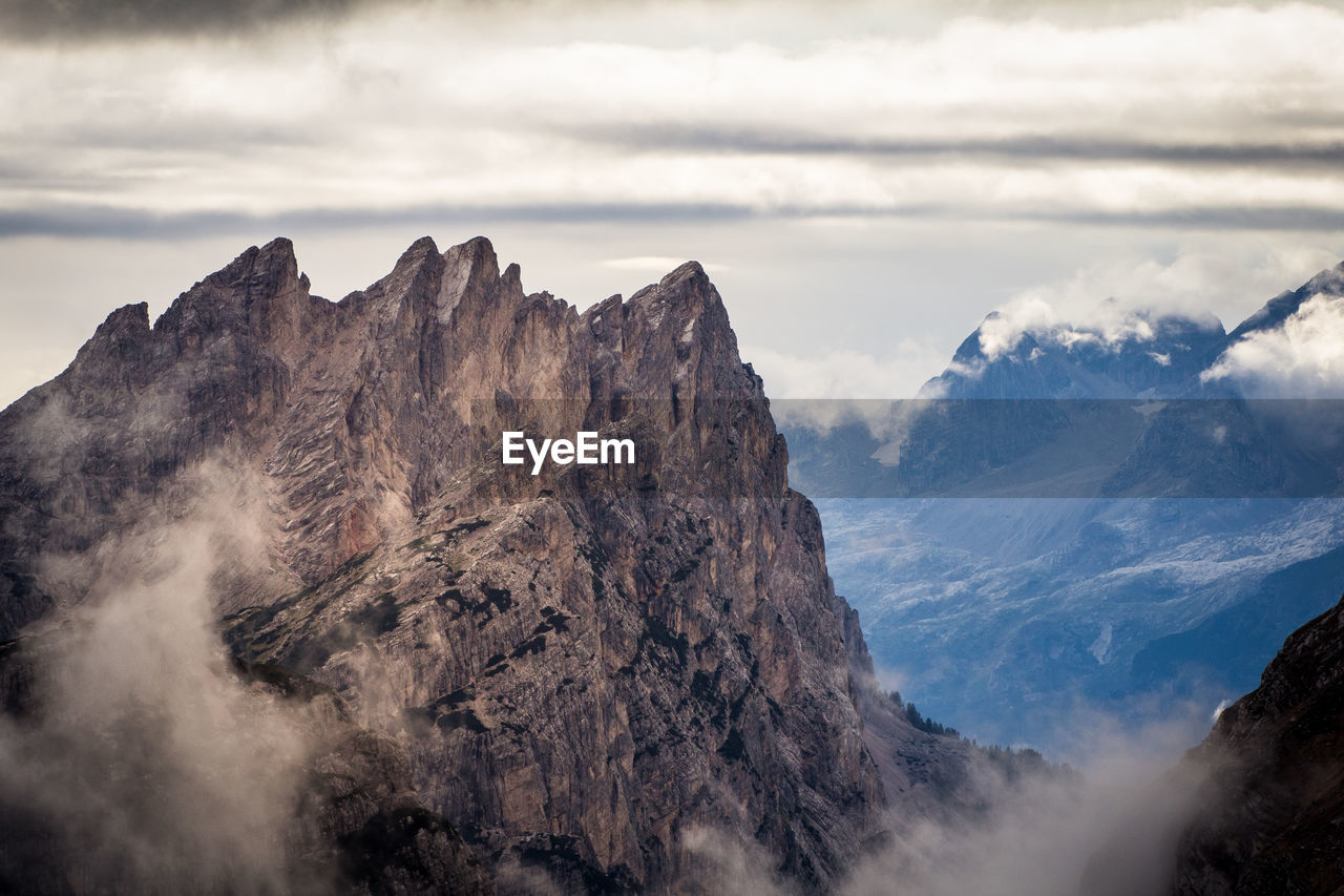 Scenic view of mountains against cloudy sky