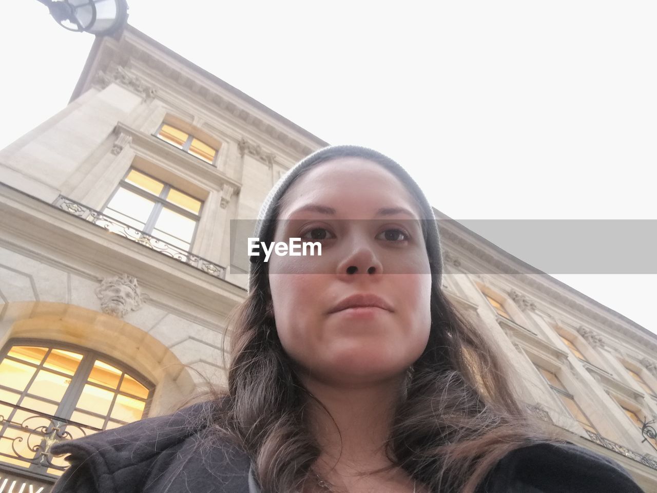 LOW ANGLE PORTRAIT OF YOUNG WOMAN LOOKING AT CAMERA