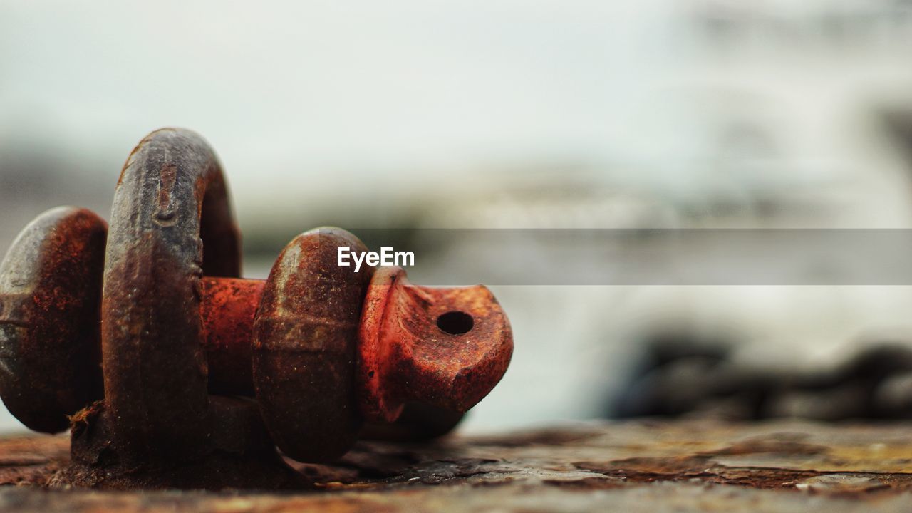 CLOSE-UP OF OLD RUSTY METAL ON CHAIN