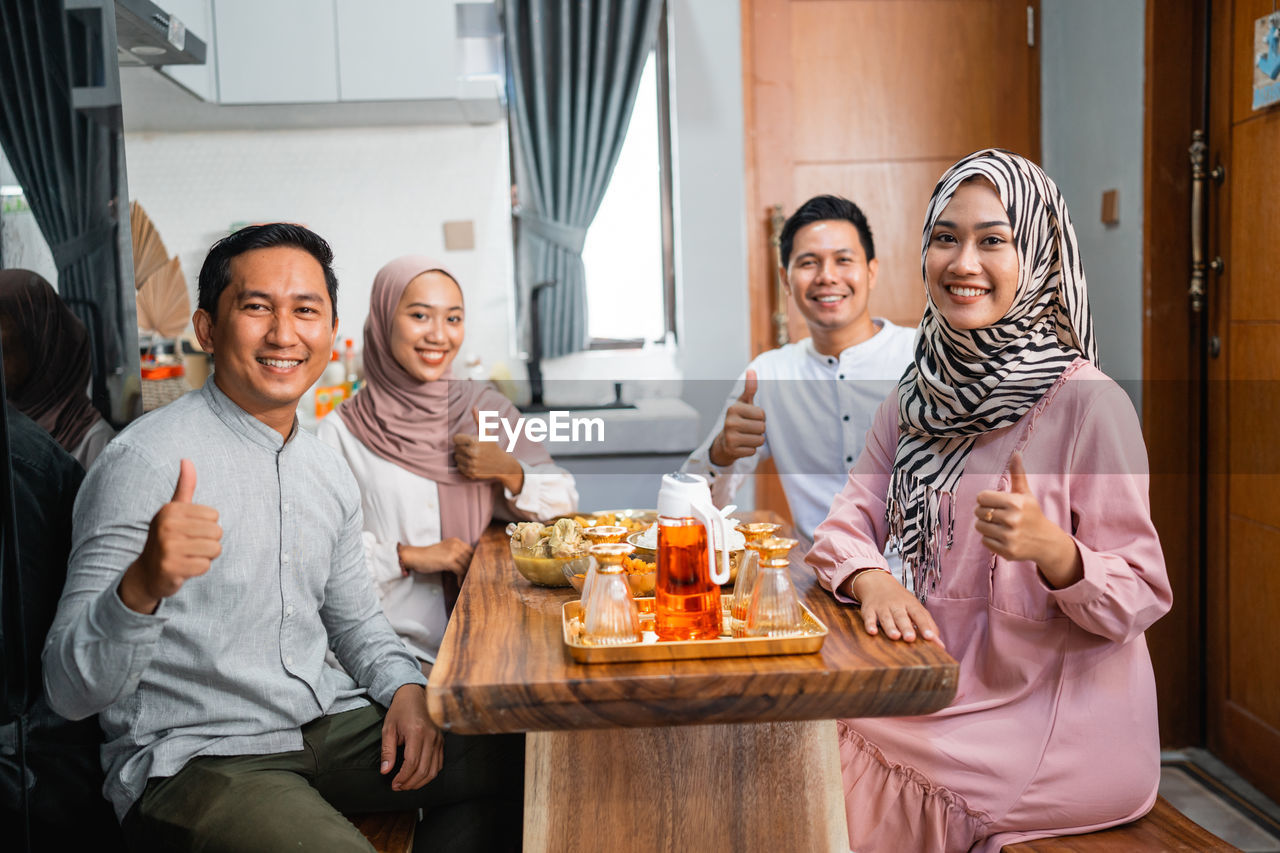 portrait of smiling friends sitting at table