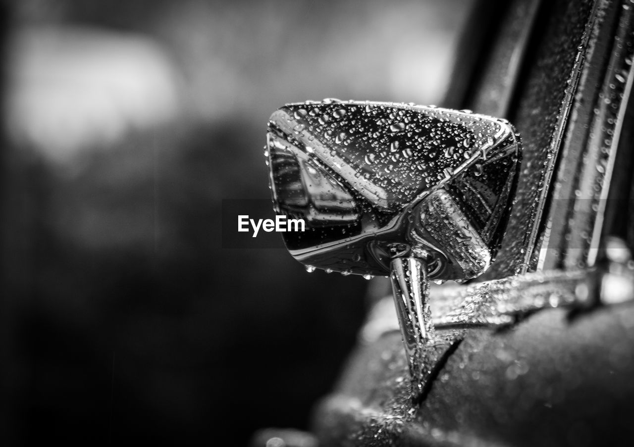 Water drops on side-view mirror of car