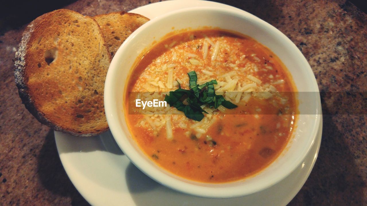 Close-up of tomato soup and breads