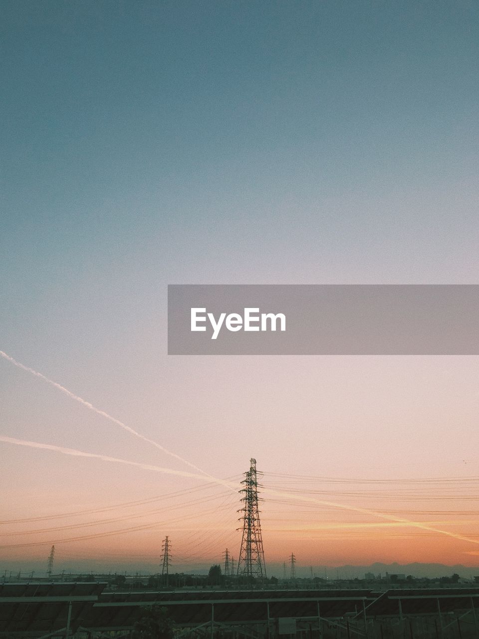 ELECTRICITY PYLON ON LAND AGAINST SKY DURING SUNSET