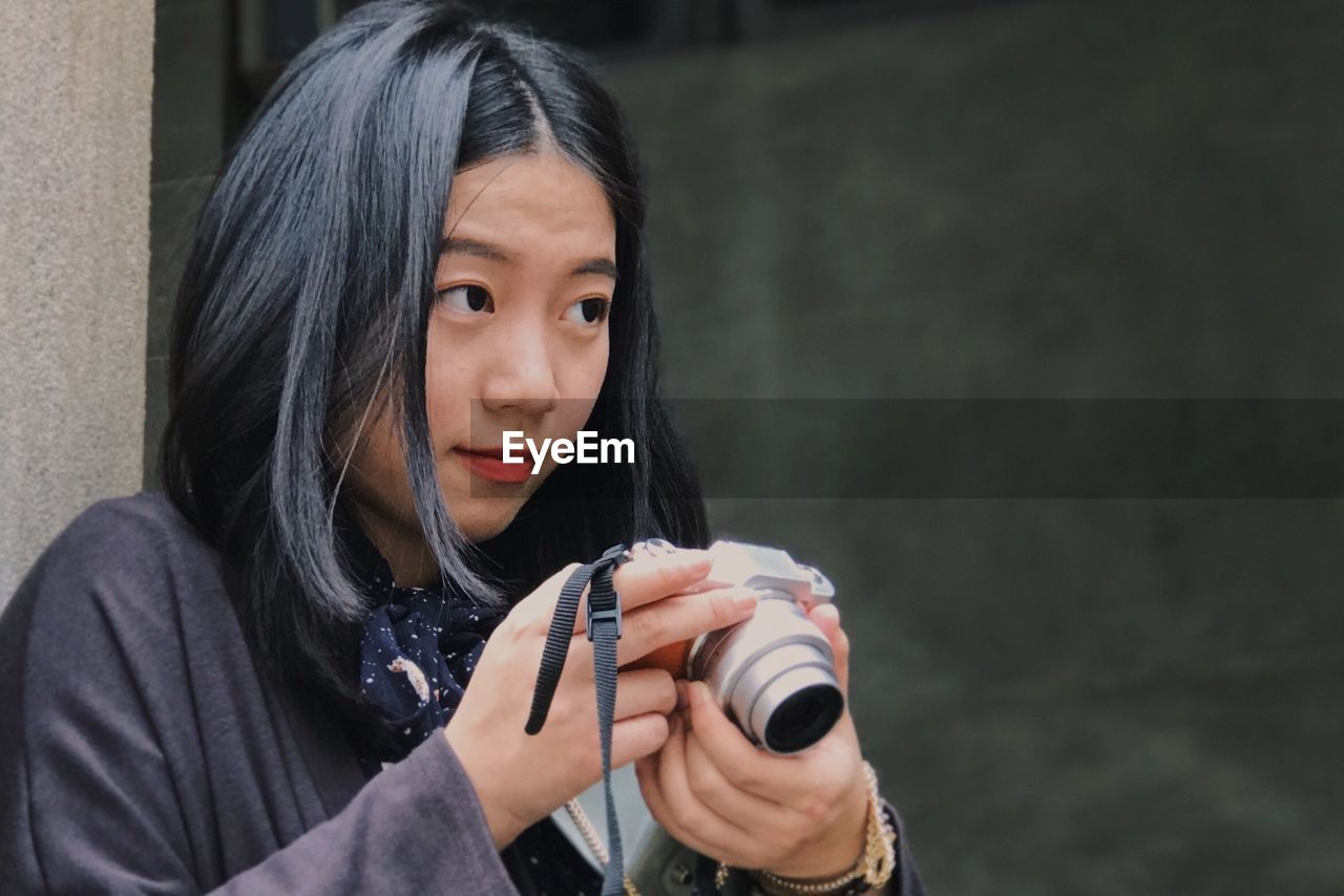 Close-up of woman holding camera