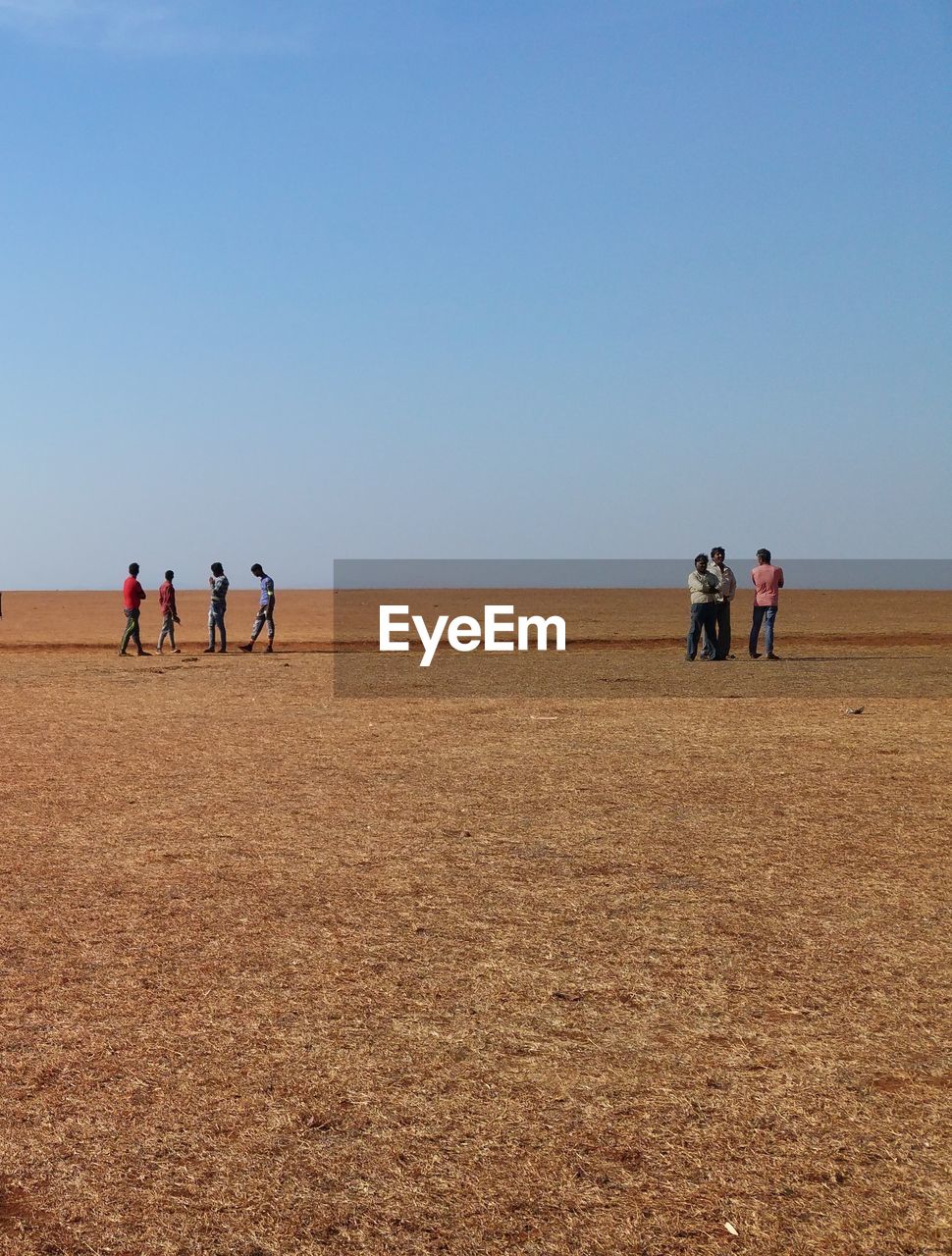 PEOPLE STANDING ON BEACH