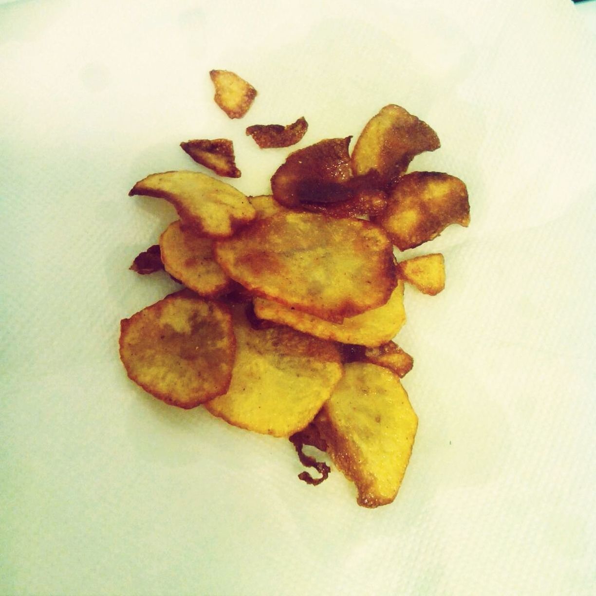 Close-up of fried potato chips on tissue paper