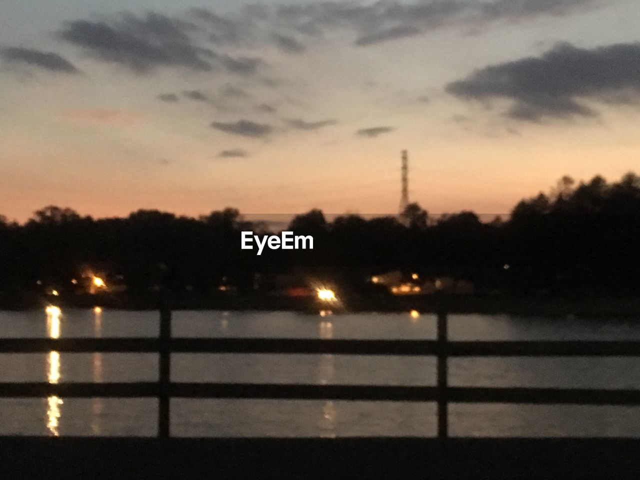 SILHOUETTE OF BRIDGE OVER RIVER AT DUSK