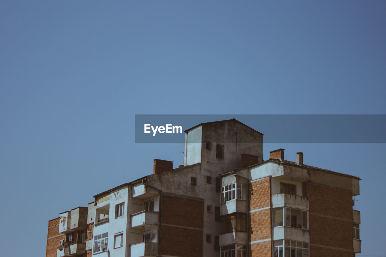 Low angle view of buildings against clear blue sky