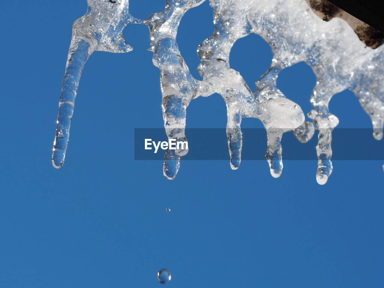 CLOSE-UP OF ICE CRYSTALS AGAINST BLUE SKY