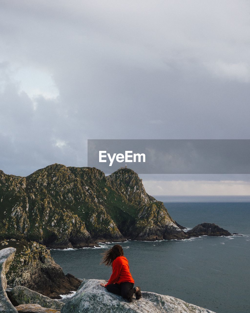 REAR VIEW OF PEOPLE LOOKING AT SEA AGAINST SKY