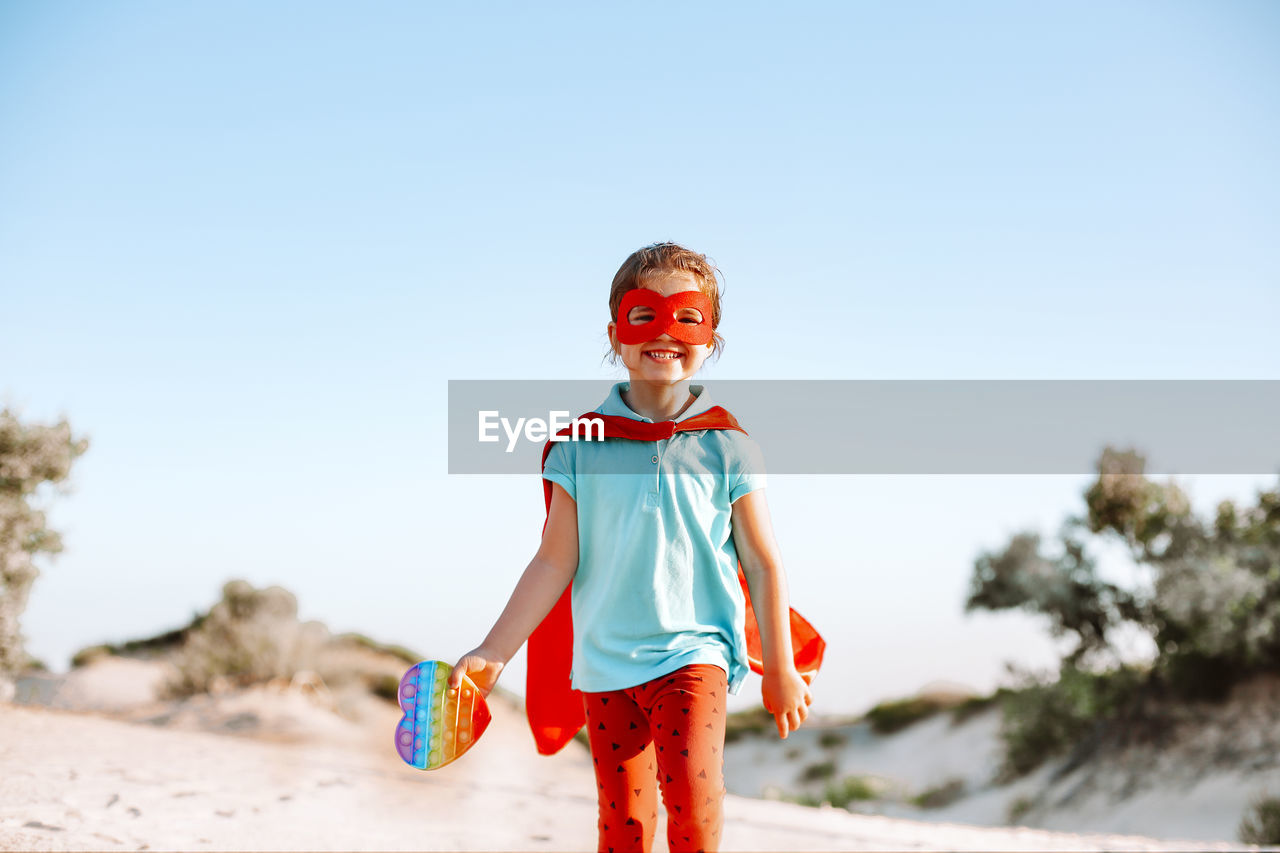 Portrait of boy standing against clear sky