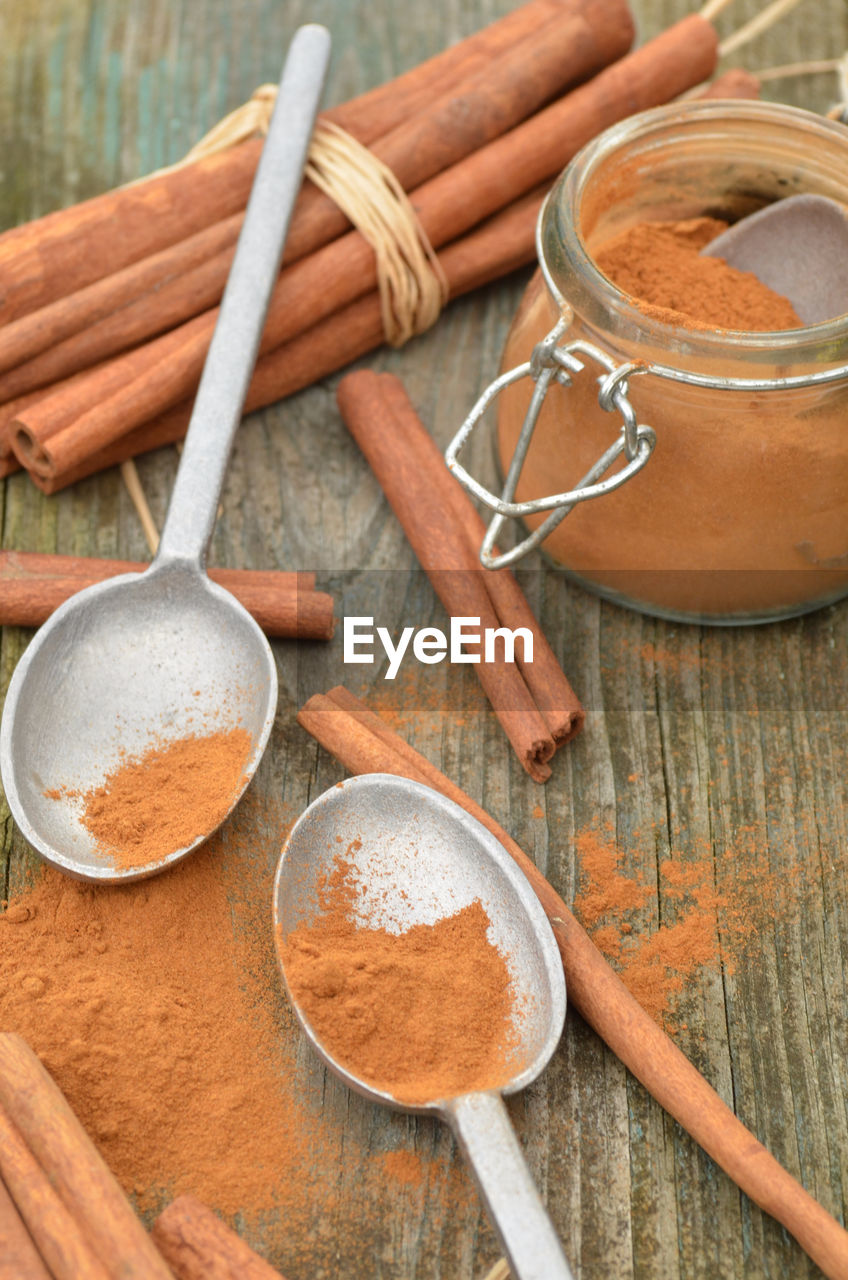 Cinnamon powder spice, cinnamon sticks, spice jar, pewter spoons,