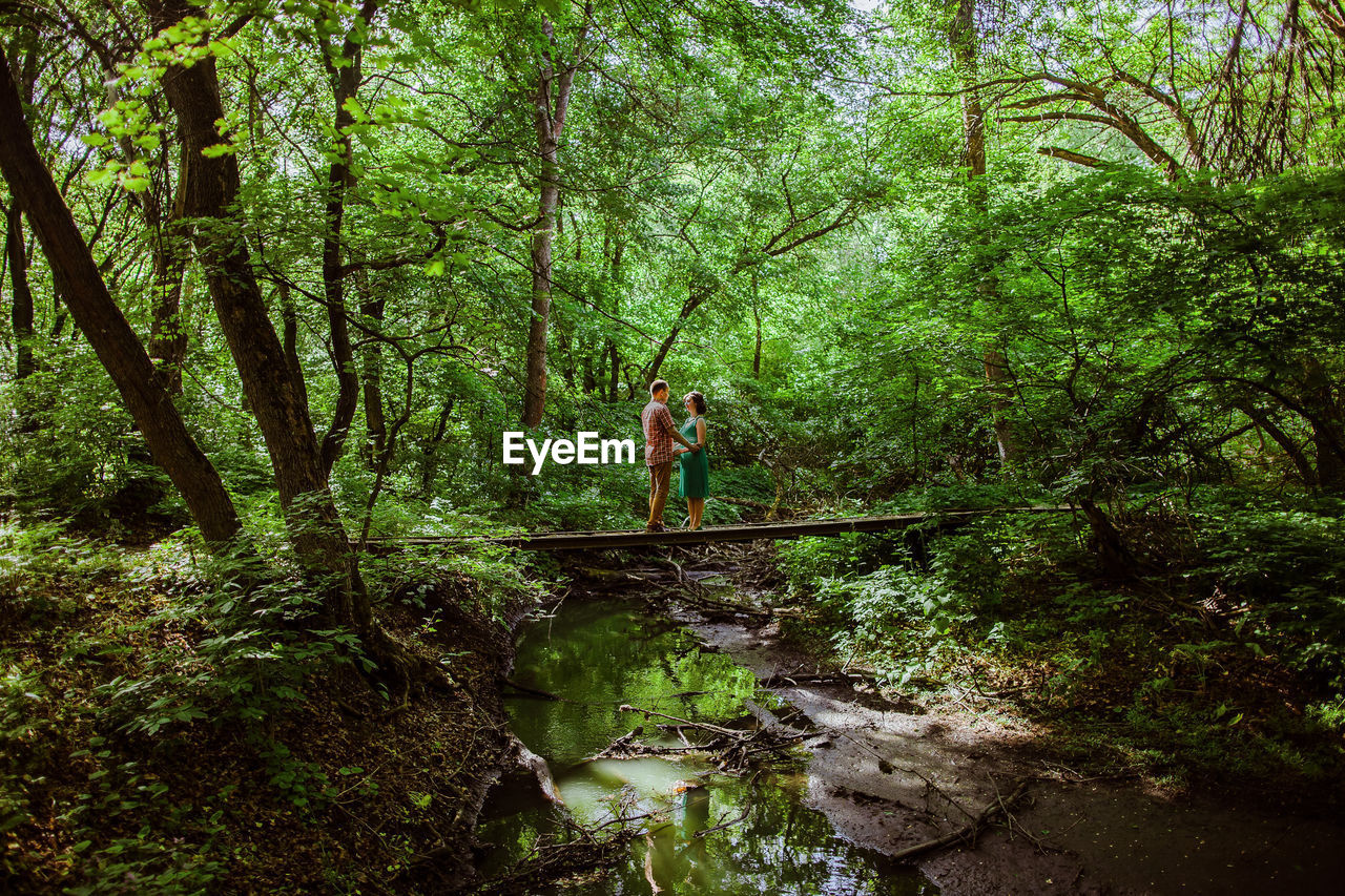 MAN STANDING IN FOREST