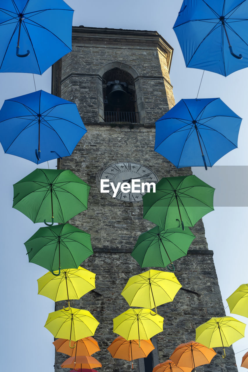 LOW ANGLE VIEW OF MULTI COLORED UMBRELLA AGAINST BUILDING