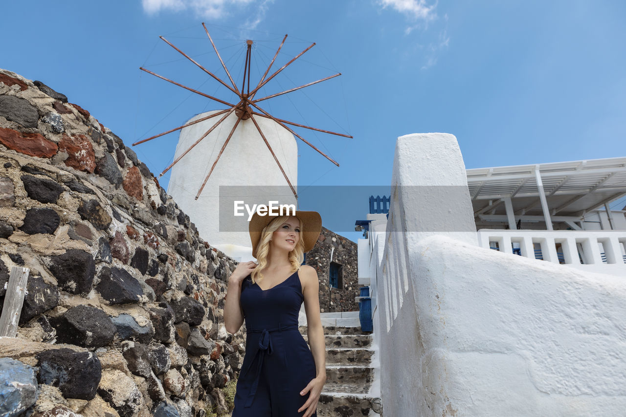 Smiling woman in hat against traditional windmill