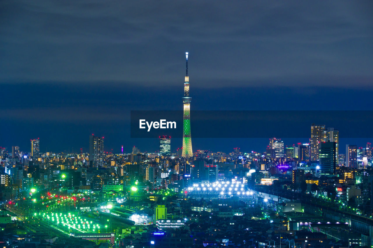 Illuminated buildings in city against sky at night