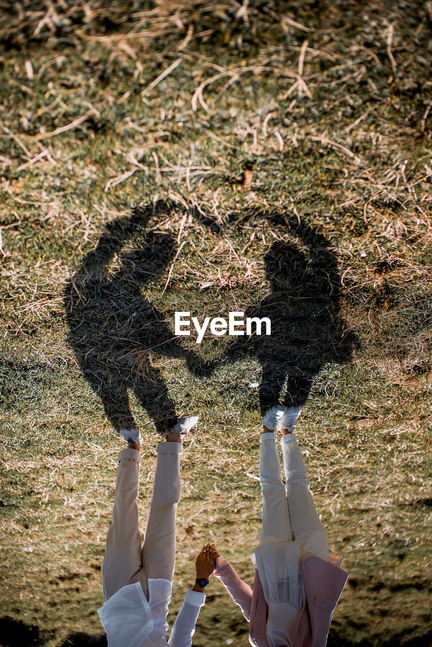 Shadow of couple standing on field