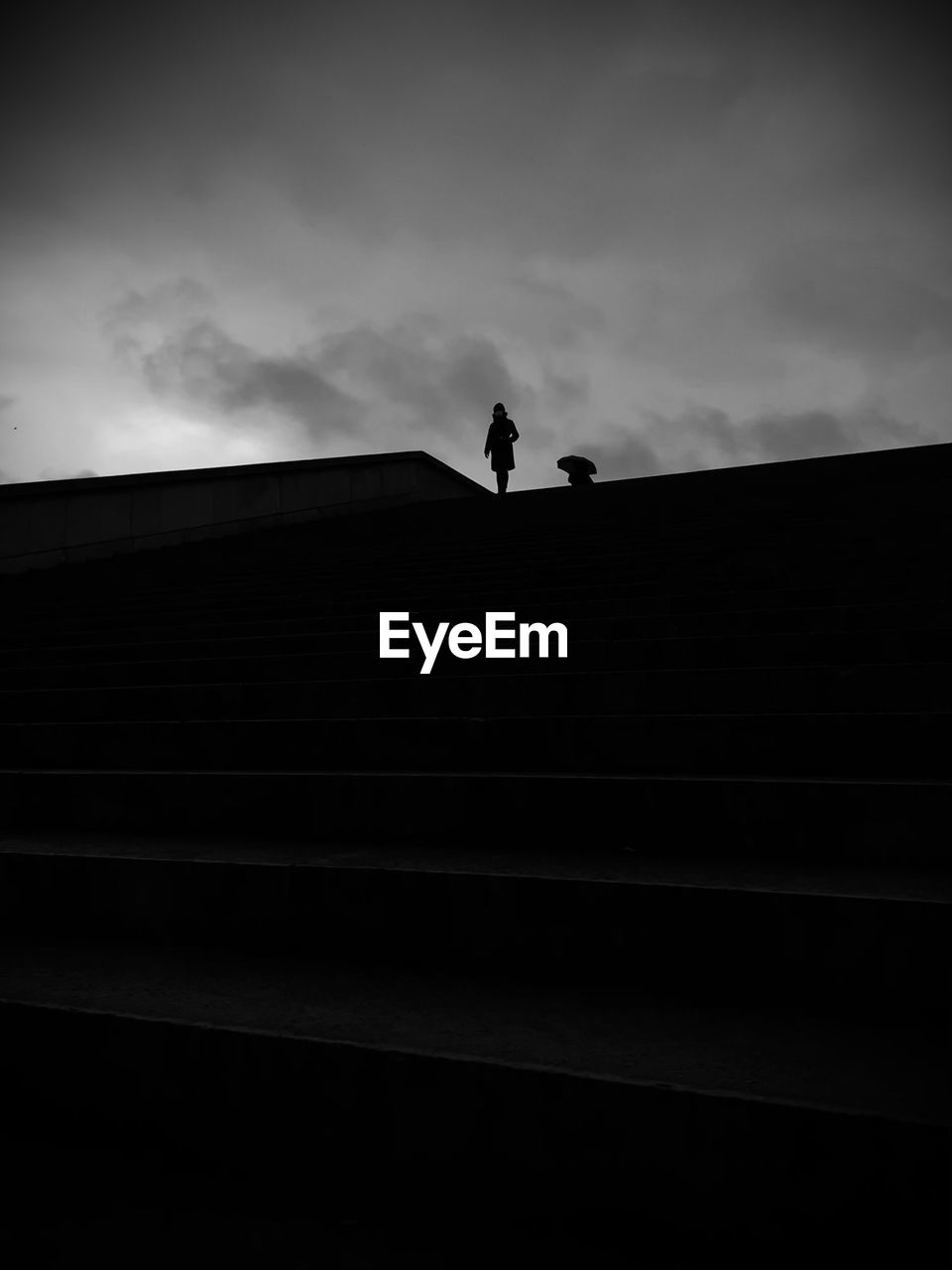 Low angle view of silhouette woman standing on staircase